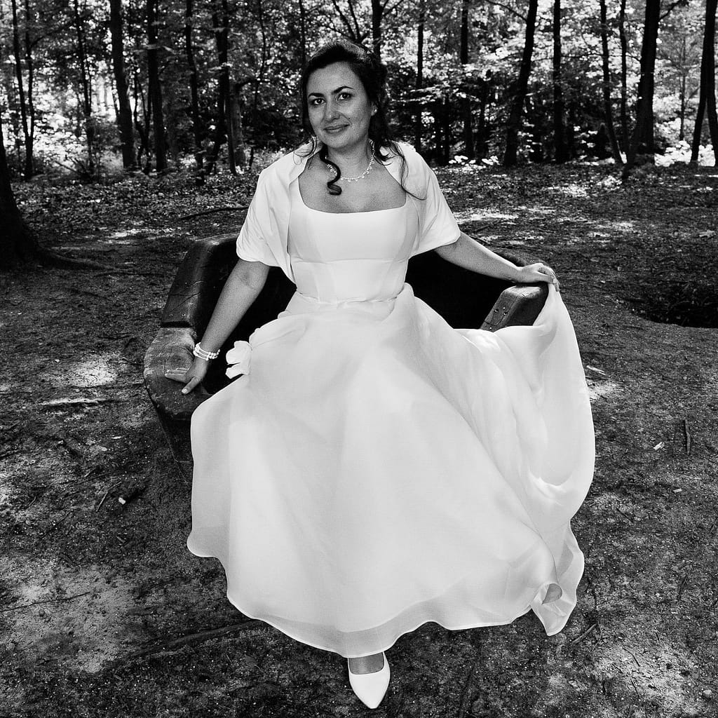 Die Braut sitzt im Wald vom Stadtpark in Hamburg Winterhude bei den Brautpaarfotos beim Hochzeitsfotograf Hamburg