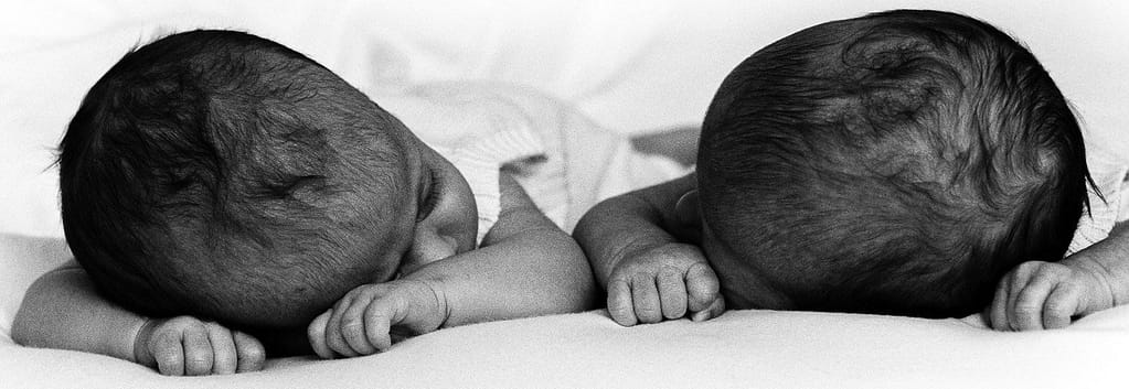 Schlafende Zwillinge nebeneinander auf dem Bauch liegend beim Baby Fotoshooting in Hamburg Neustadt