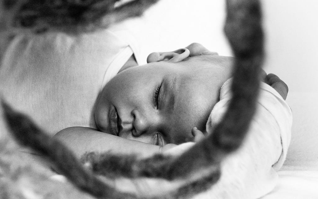Baby liegt auf dem Bett und schläft beim Baby Fotoshooting in Hamburg Eppendorf