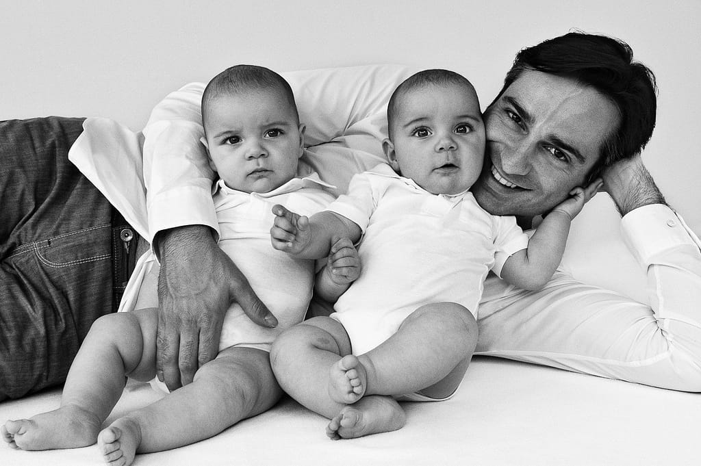 Papa kuschelt mit seinen beiden Zwillingen beim Babyfotograf in Hamburg Harvestehude
