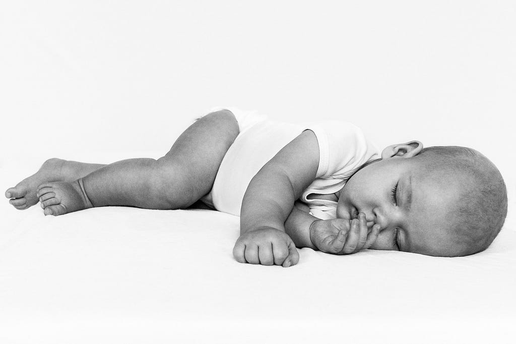 Baby liegt auf dem Bett und schläft beim Baby Fotoshooting in Hamburg Eppendorf