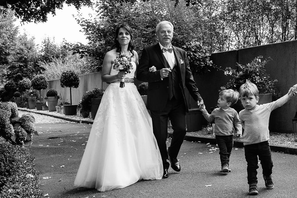 Der Brautvater führt die Braut zur Trauzeremonie an der Villa im Jachthafen bei Hochzeitsfotografie Hamburg