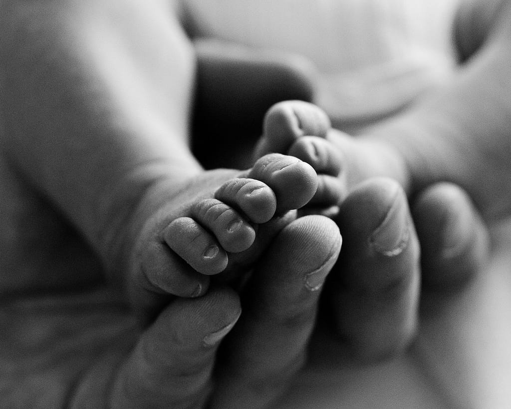 Babyfüsse in Papas Hand bei der Neugeborenenfotografie in Hamburg Harburg
