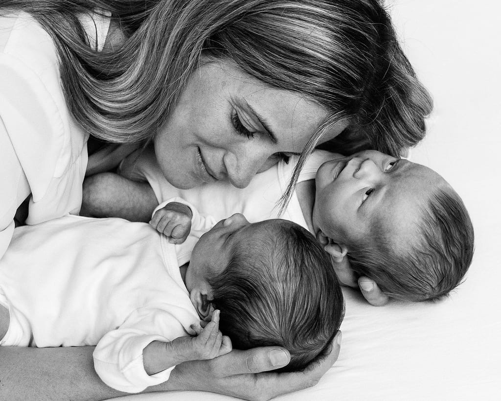 Mama und Zwillinge kuscheln gemeinsam auf der Decke beim Baby Fotoshooting in Hamburg Barmbek