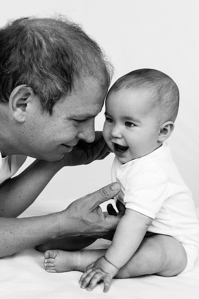 Papa kitzelt sein Baby und es lacht beim Baby Fotoshooting in Hamburg Eimsbüttel