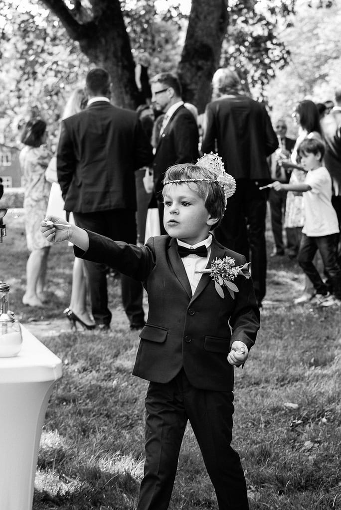 Der kleine Sohn des Hochzeitspaars im Hochzeitsanzug beim Sektempfang im Seelemannpark an der Eppendorfer Hochzeitskirche beim Hochzeitsfotograf Hamburg