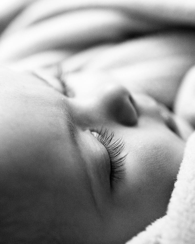 Nahaufnahme einer langen Wimper eines schlafenden Babys beim Baby Fotoshooting in aller Ruhe zuhause