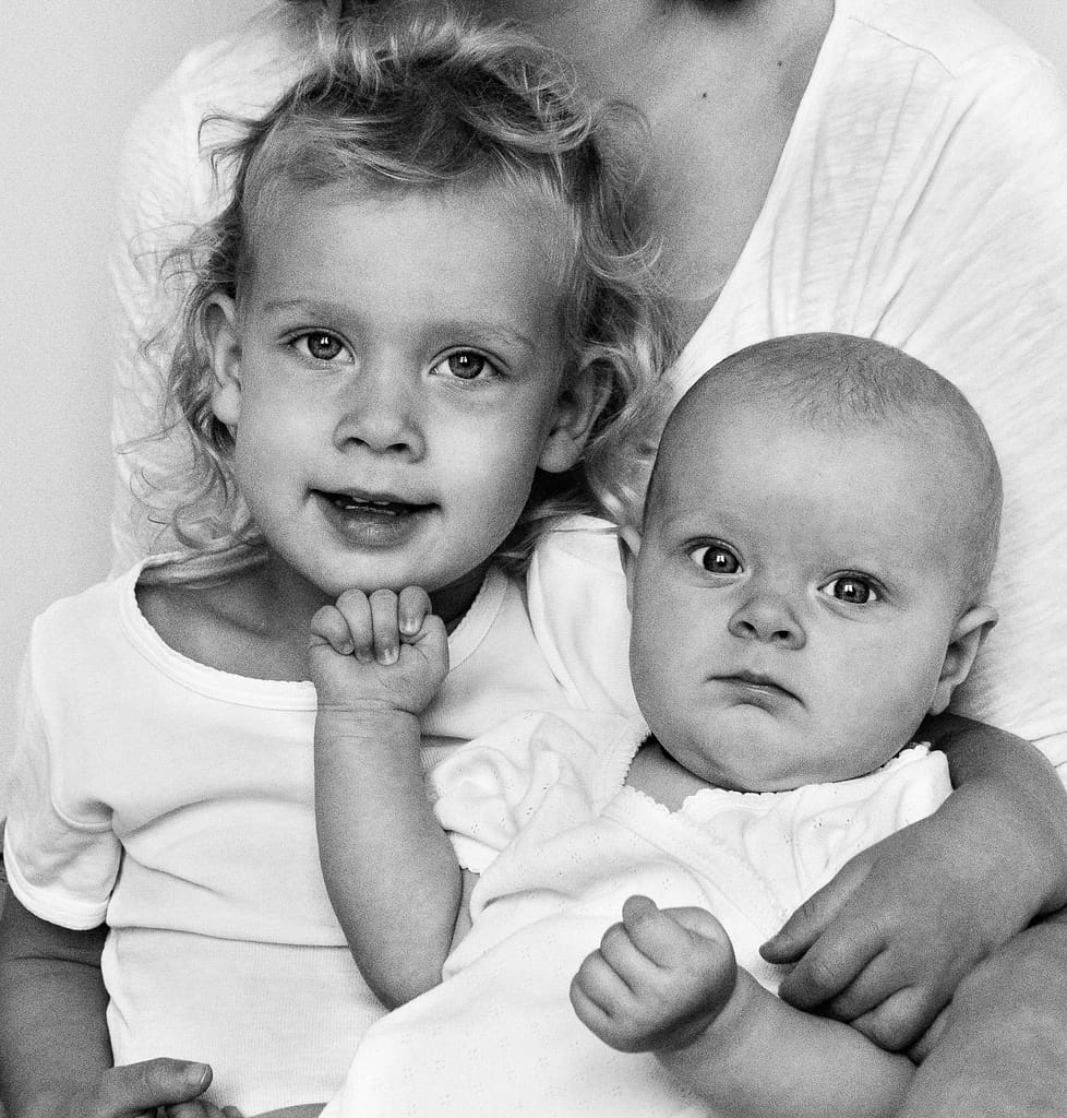 Großer Bruder hält Baby im Arm beim Baby Fotoshooting in Hamburg Winterhude