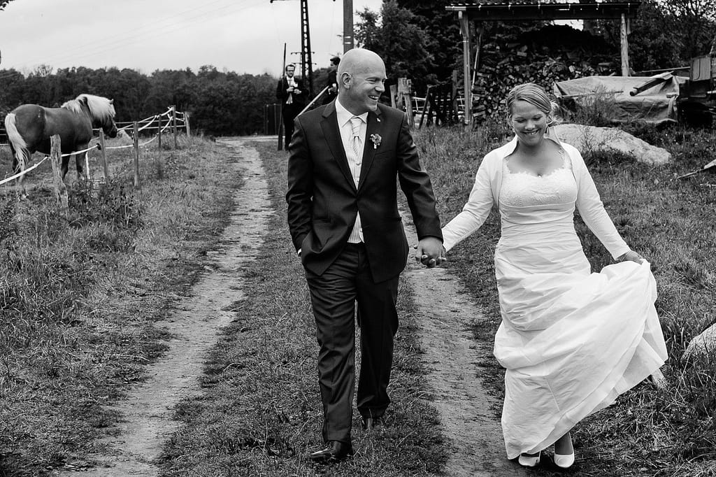 Hochzeitspaar bei der Landhochzeit läuft gemeinsam über die Felder am Gutshof Woldzegarten in Mecklenburg Vorpommern beim Hochzeitsfotograf Landhochzeit Hamburg