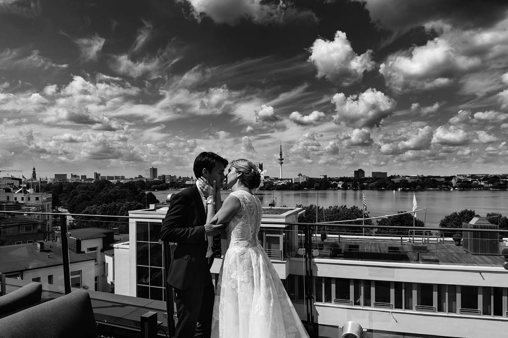 Hochzeitskuß mit Panorama Blick über die Aussenalster von der Dachtersse vom Hotel The George in Sankt Georg beim Hochzeitsfotograf Hamburg