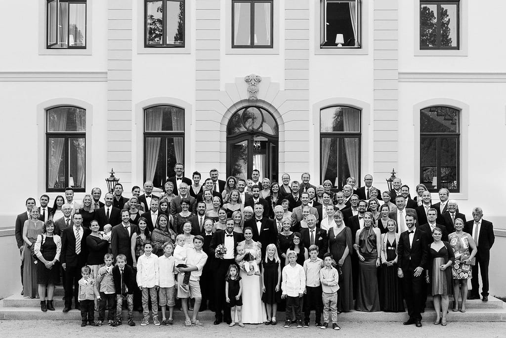 Gruppenfoto der Hochzeitsgesellschaft auf der Treppe zum Schloß Weissenhaus Grand Village Resort an der Ostsee beim Hochzeitsfotograf Hamburg
