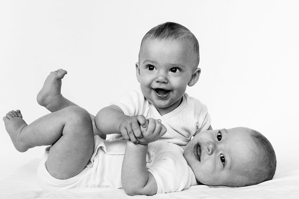 Zwillinge spielen miteinander auf der Decke beim Baby Fotoshooting in Hamburg Langenhorn