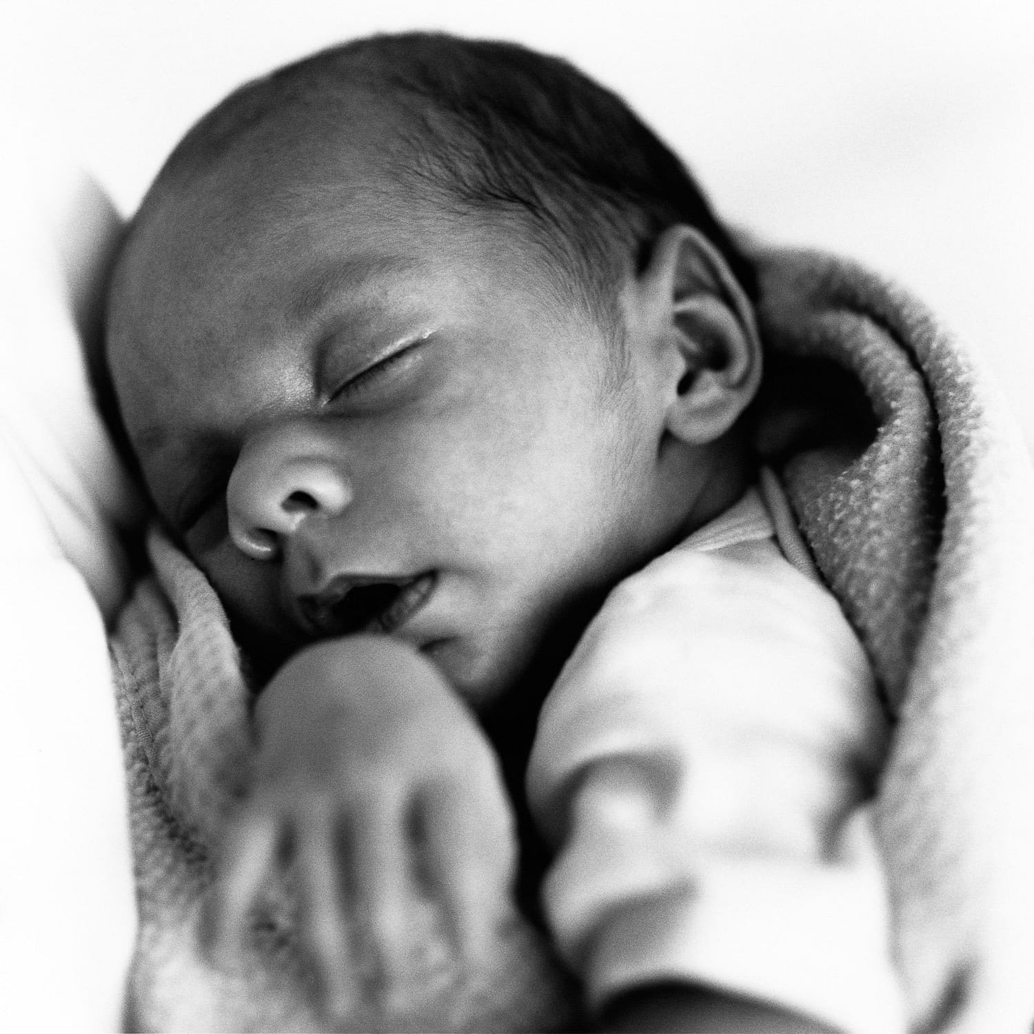 Schlafendes Baby im Arm seiner Mutter bei der Neugeborenenfotografie in Hamburg Sasel