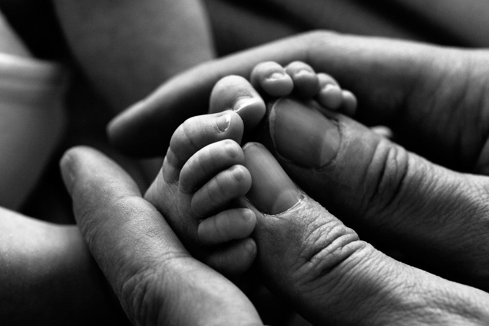 Babyfüsschen in Papas Händen bei der Neugeborenenfotografie in Hamburg Harburg