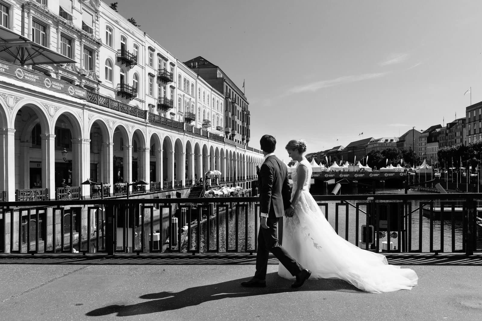 Das Hochzeitspaar flaniert an den Alsterarkaden in der Hamburger Innenstadt beim Hochzeitsfotograf Hamburg