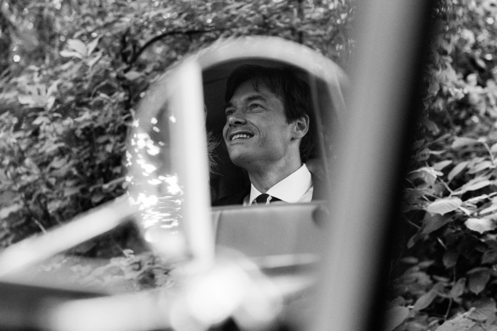 Der Bräutigam freut sich über eine Fahrt mit dem Hochzeitsauto VW Bulli T1 am Goldschätzchen der Koch Fabrik auf dem Golf Park Peiner Hof in Priesdorf beim Hochzeitsfotograf Hamburg