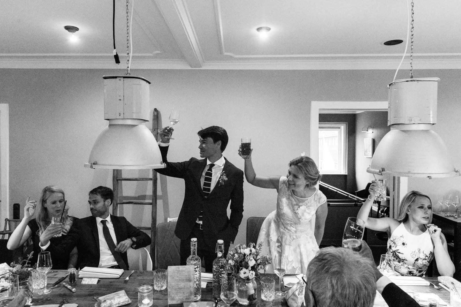 Das Hochzeitspaar und die Hochzeitsgäste stoßen auf die Hochzeitsfeier an im Goldschätzchen der Koch Fabrik auf dem Golf Park Peiner Hof in Priesdorf beim Hochzeitsfotograf Hamburg