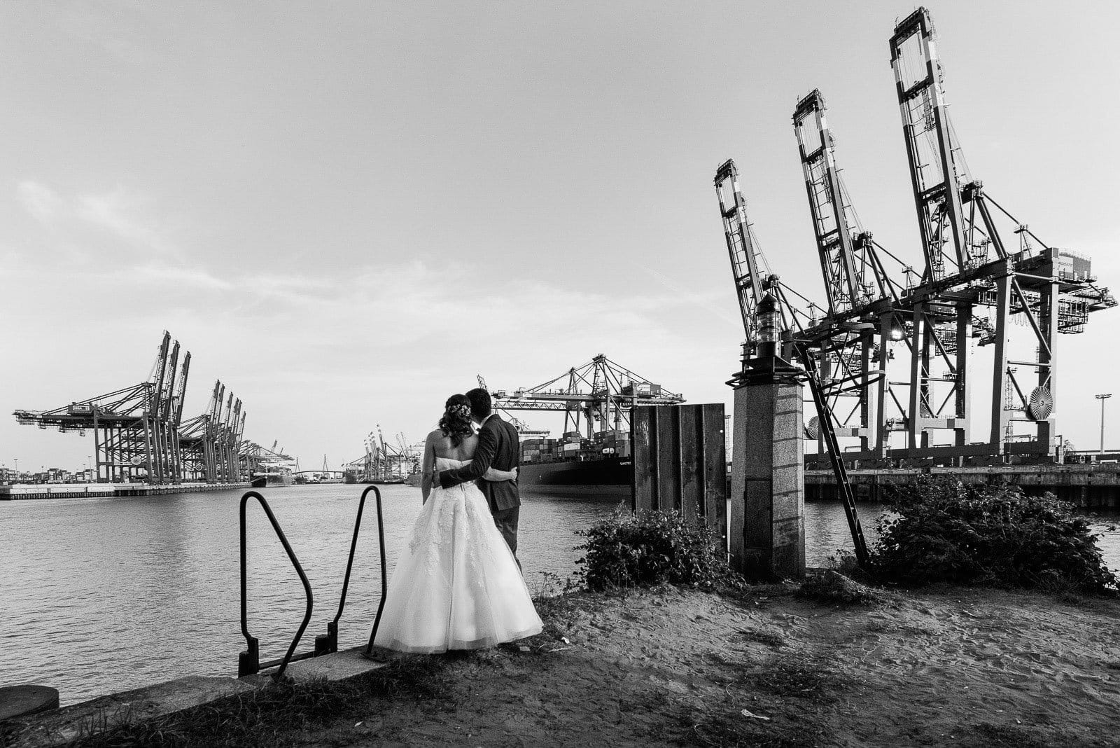 Hochzeitspaar genießt den Blick vom Parkhafen auf den Waltershofer Hafen und die Köhlbrandbrücke bei Hochzeitsfotografie Hamburg