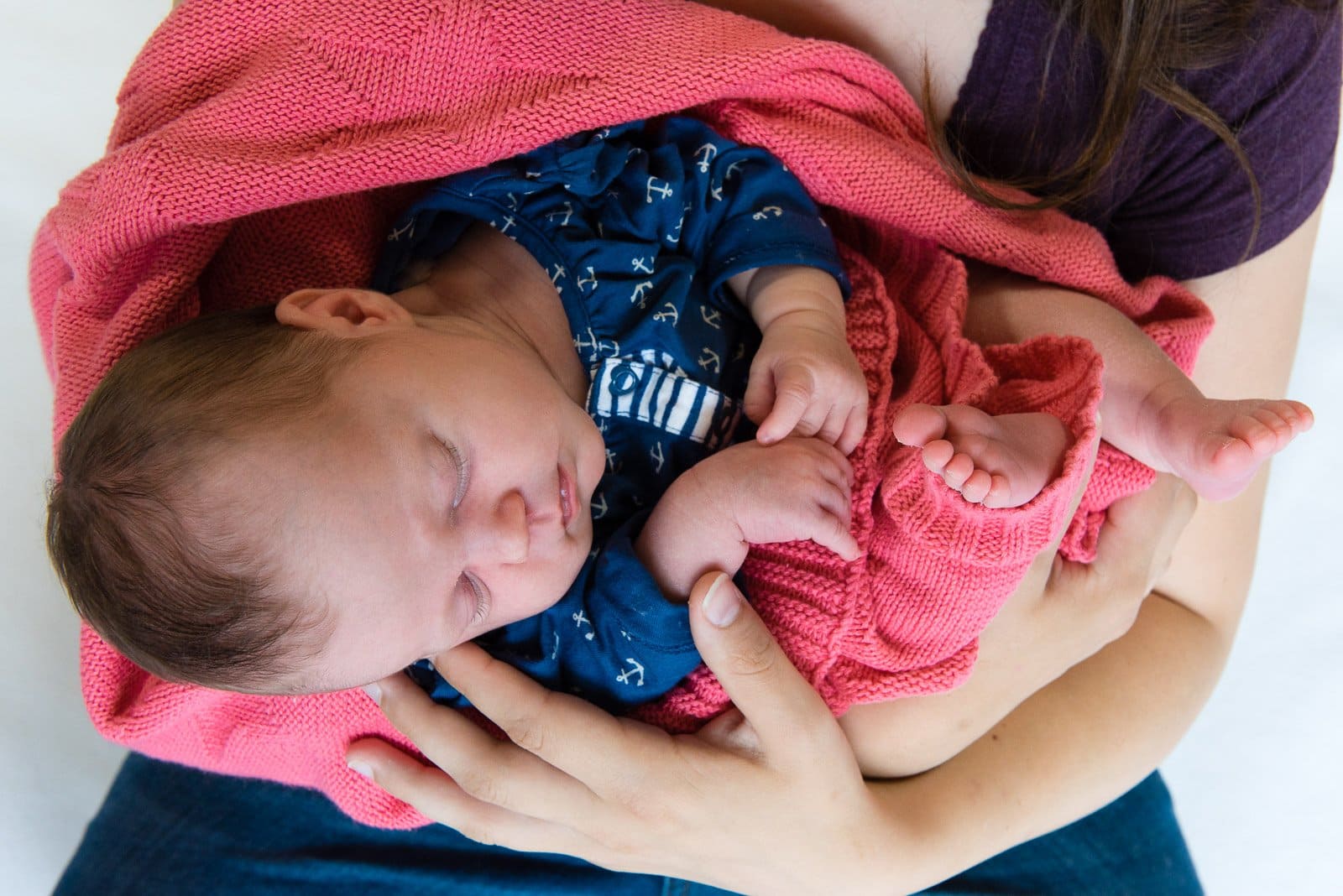 Mutter hält schlafendes Baby in den Armen beim Baby Fotoshooting in Halstenbek bei Hamburg