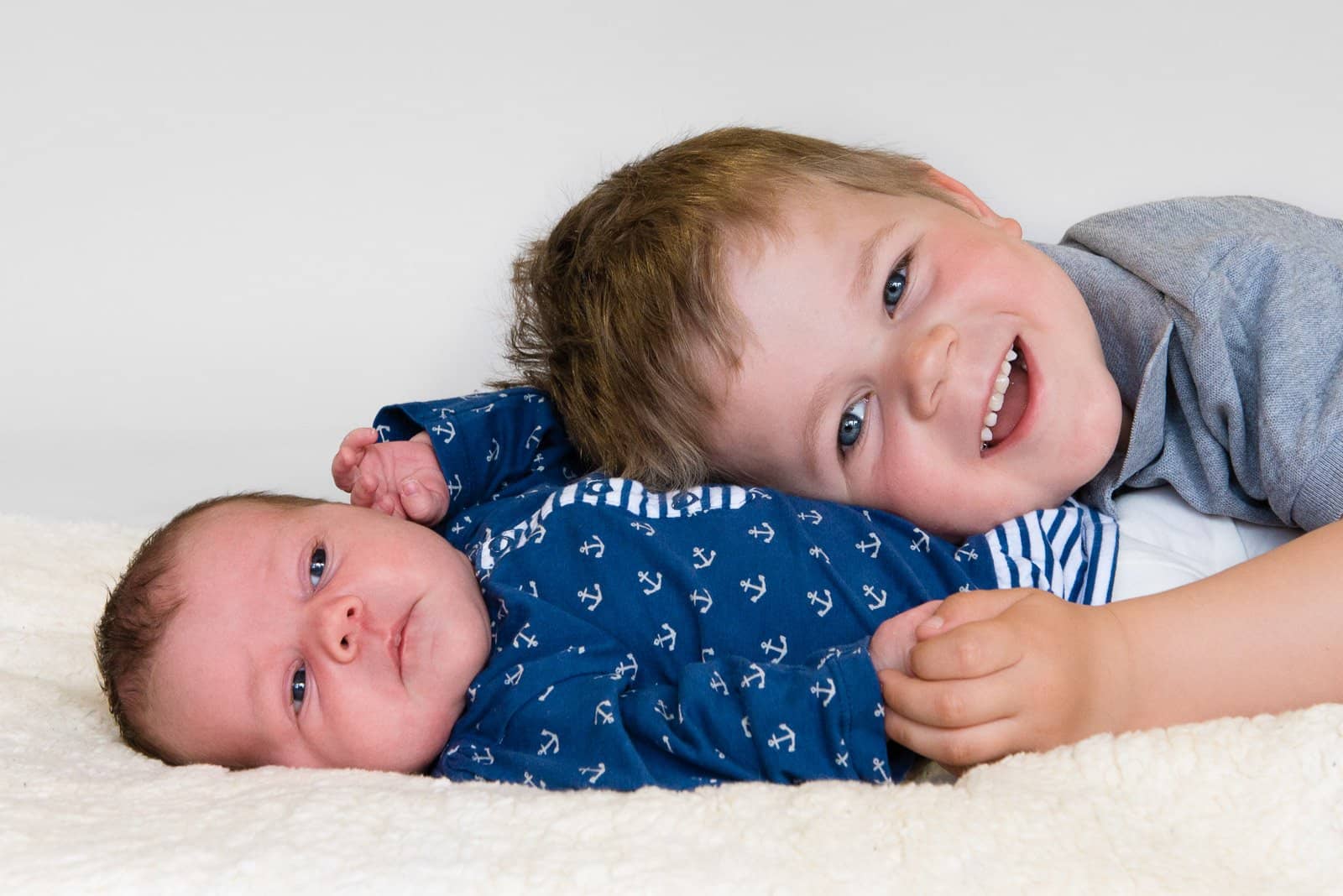 Geschwisterkind kuschelt sich an das Baby beim Baby Fotoshooting in Hamburg Blankenese
