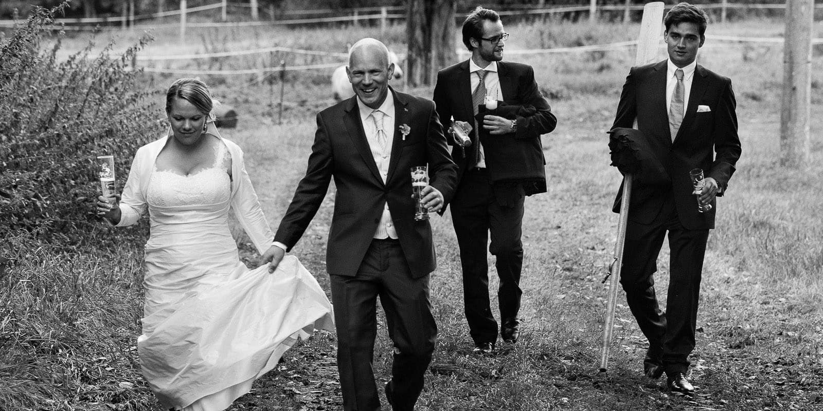 Hochzeitspaar mit Trauzeugen bei der Landhochzeit läuft gemeinsam über die Felder am Gutshof Woldzegarten in Mecklenburg Vorpommern beim Hochzeitsfotograf Hamburg