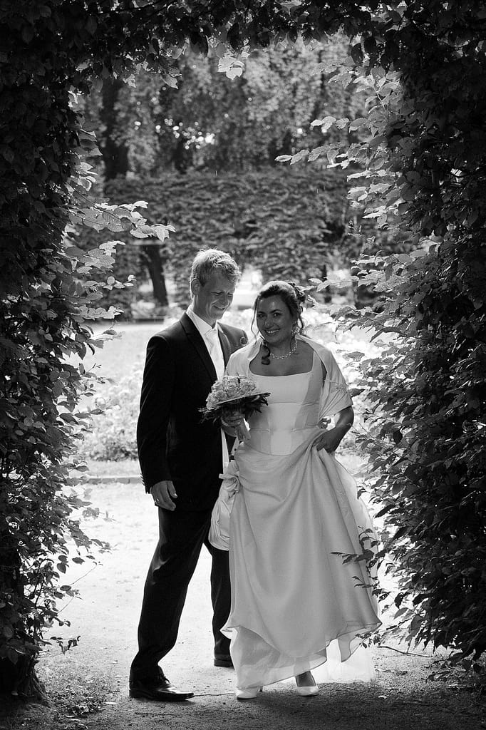 Hochzeitspaar spielt im Adam und Eva Heckengarten im Hamburger Stadtpark in Winterhude bei den Brautpaarfotos beim Hochzeitsfotograf Hamburg