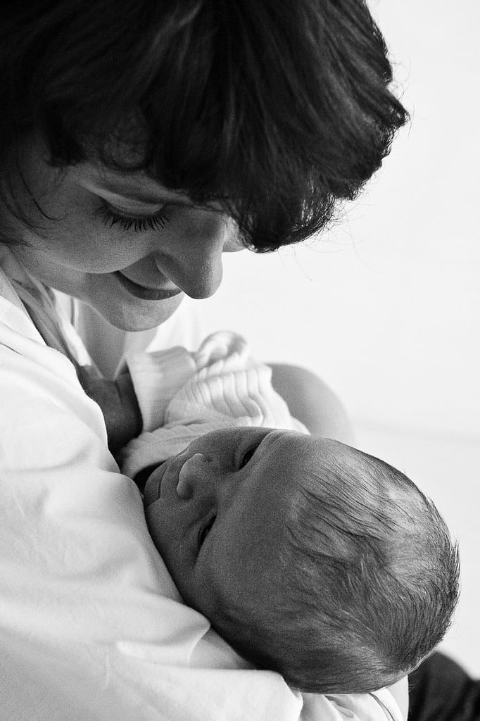 Mama hält ihr Baby im Arm bei der Neugeborenenfotografie in Hamburg Harburg