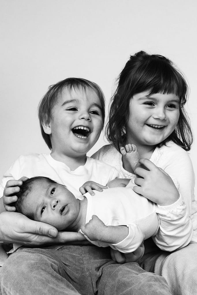 Geschwister kuscheln mit Baby beim Baby Foto Shooting in Hamburg