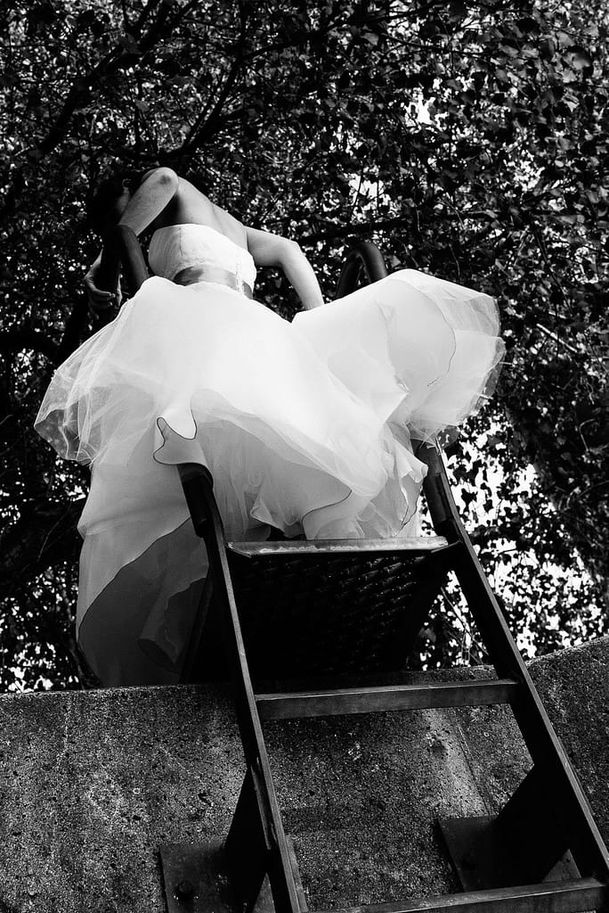 Die Braut klettert im Parkhafen über die Flutschutzmauer bei Hochzeitsfotografie Hamburg